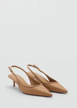 Zapato destalonado color beige con punta fina, detalle de tachuelas y cierre con hebilla.