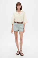 Short de jean de tiro alto con diseño de rayas verticales celestes y blancas, bolsillos laterales y vuelta en el ruedo.