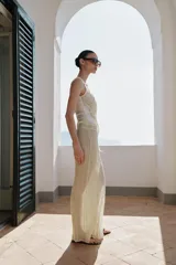 Pantalón de pierna ancha y tiro medio, confeccionado en tejido con textura arrugada. Presenta una cintura elástica destacada por un detalle de tejido en crochet a tono.