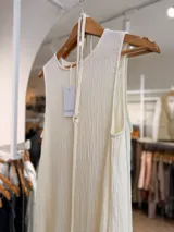 Vestido largo negro sin mangas, confeccionado en tela texturada con relieve, de corte fluido y diseño versátil.