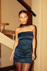 Vestido corto strapless color petróleo, con textura elástica fruncida y pieza de tul en el ruedo. Incluye cuello desmontable de tul.