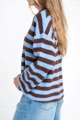 Sweater de punto con diseño de rayas horizontales en color marrón y celeste, corte oversize, cuello polo con cierre frontal y mangas largas.