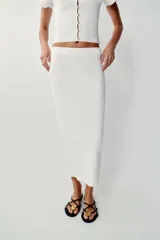 Falda midi tubo de punto color blanco, de corte recto y cintura elástica.