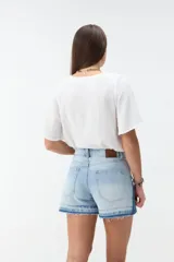 Short de denim blanco de tiro medio, con costuras pespuntadas en contraste y terminación desmechada en el ruedo.