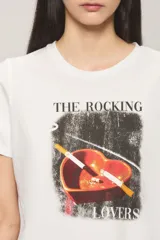 Remera de jersey de algodón blanca con calce regular, cuello redondo y mangas cortas. Presenta una estampa frontal con la leyenda "The Rocking Lovers" y una imagen de un cenicero en forma de corazón con cigarrillos.