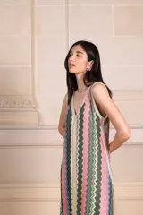 Vestido largo de tejido de punto con estampado de zig-zag vertical en tonos rosados, verdes, beige y lila. Presenta escote en V pronunciado tanto en el frente como en la espalda, con vivos de punto con lurex.