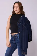 Campera de jean de mujer, color azul claro lavado, con corte cropped y estilo clásico. Presenta cuello camisero, botones metálicos frontales y bolsillos de parche en el pecho.