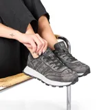 Zapatillas urbanas negras de tela con cordones y suela blanca de PVC.