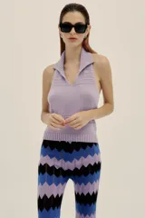 Pantalón tejido con diseño de ondas en tres colores, lila, azul y negro. Presenta pequeños calados en líneas verticales y cintura elastizada.