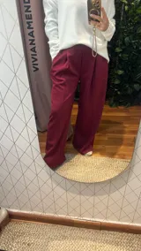 Pantalón de corte ancho y tiro alto, con cintura elástica y pinzas frontales. Presenta un diseño holgado y fluido, confeccionado en tejido de algodón.