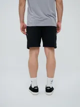 Bermuda deportiva Umbro modelo Veliz para hombre, color negro con detalles en blanco, cordón ajustable en la cintura y logo bordado en la pierna izquierda.