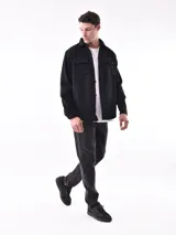 Sobrecamisa a cuadros azul y gris con cuello clásico, cierre frontal con botones, dos bolsillos con solapa abotonada en el pecho y puños abotonados.