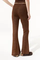 Pantalón negro de lurex elastizado, de tiro alto y pierna acampanada.