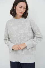 Buzo de tejido de punto con diseño floral jacquard, cuello redondo, mangas largas y puños y ruedo acanalados.