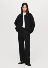 Chaqueta estilo bomber de corte recto y tejido mezcla de lana, con cuello camisero, cierre frontal con cremallera, bolsillos laterales y forro interior.