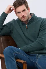 Buzo tejido de lana con cuello alto y medio cierre metálico frontal. Presenta puños y ruedo acanalados, con logo bordado en el pecho.