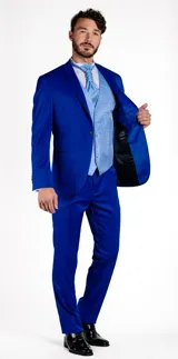 Traje de vestir compuesto por chaqueta y pantalón en color azul cobalto. La chaqueta presenta solapas en punta de raso al tono, cierre de un botón y bolsillos de doble vivo. El pantalón es de corte recto y diseño formal.