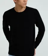 Suéter de punto color borgoña, con cuello redondo, sisas ligeramente desplazadas y bajo y puños acanalados.