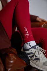 Calza deportiva de tiro alto en color bordó, confeccionada en tejido elástico con diseño sin costuras.