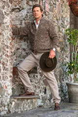 Pantalón de vestir color beige, de corte recto, con bolsillos laterales y traseros. Se ajusta a la cintura con cinturón de cuero marrón.