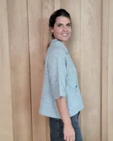 Cardigan de punto color arena, con cuello camisero, cierre frontal de botones y mangas cortas con terminación acanalada. Presenta dos bolsillos frontales tipo parche.