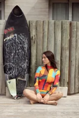Enteriza de surf de lycra con mangas largas y espalda abierta. Diseño geométrico multicolor en tonos naranja, amarillo, verde, azul y rojo.