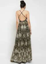 Vestido largo de fiesta confeccionado en tela mesh con acabado glitter. Presenta un diseño con escote en V profundo, breteles finos y falda amplia con caída fluida.