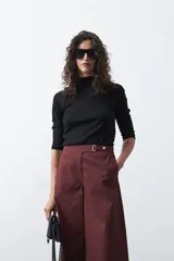 Pantalón wide leg de corte sastrero, color negro, con cintura de tiro medio y diseño de pernera amplia y relajada.