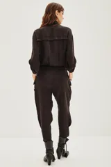 Enterito de estilo utilitario color negro, con cierre frontal, bolsillos en el pecho, mangas tres cuartos y lazo ajustable en la cintura.