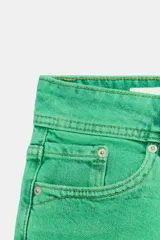 Shorts de jean tiro bajo color verde, con diseño clásico de cinco bolsillos, trabillas para cinto y cierre frontal con cremallera y doble botón metálico.