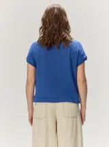 Remera negra de punto fino, con mangas cortas, cuello redondo y corte relajado. Cuenta con costuras verticales decorativas en el frente.
