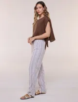 Pantalón de lino de calce holgado y caída ligera, con estampado de rayas verticales en tonos celestes y blancos. Cuenta con cintura elastizada fruncida con cordón ajustable al frente, bolsillos laterales y pierna recta.