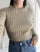 Sweater tejido de punto color beige, con cuello redondo y mangas largas.