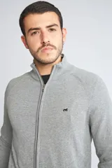 Campera tejida de algodón con cierre frontal completo, cuello alto y mangas largas. Presenta un diseño básico con logo bordado en el pecho.