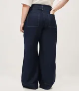 Pantalón de jean wide leg color azul oscuro, confeccionado en algodón resistente, de tiro alto con costuras frontales destacadas en las piernas y diseño de pernera ancha.