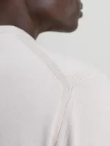 Sweater de hombre Calvin Klein de corte regular, color beige claro, con cuello redondo y puños y bajo de canalé. Presenta una pequeña etiqueta con el logo de la marca sobre el bajo.