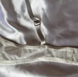 Conjunto de lencería de dos piezas color blanco, confeccionado en tela suave y semitransparente con detalles de encaje en los bordes. Incluye un bralette triangular sin aro ni relleno, con breteles regulables y una bombacha vedetina a juego.
