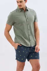 Short de baño azul marino con bordado de pequeñas palmeras, cintura elástica con cordón ajustable y bolsillos laterales.