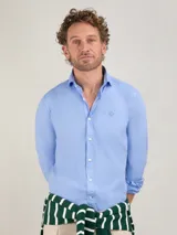Camisa celeste de popelina de algodón, corte slim fit, cuello italiano con ballenas, manga larga terminada en puño simple y logo bordado en el pecho.