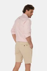Bermuda clásica de lino color beige, de corte recto con bolsillos laterales y traseros ribeteados con botón.