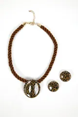 Set de collar y aros con diseño animal print de leopardo. El collar es de cordón marrón trenzado con dije circular y cadena dorada ajustable. Los aros son tipo botón.