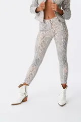 Pantalón de jean ajustado con estampado de piel de serpiente en tonos grises y beige.