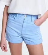Short de sarga color blanco, de cintura alta, con bolsillos delanteros y traseros, trabillas para cinturón y bajo plegado. Cuenta con cierre frontal de botón y cremallera.