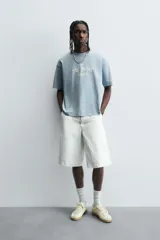 Camiseta de manga corta y cuello redondo, color celeste lavado, con estampado frontal en blanco que dice "The Mr. Rebel Dance".