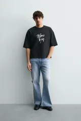 Sudadera de corte relajado confeccionada en algodón, con cuello redondo, manga corta y acabado en rib. Presenta un estampado gráfico a contraste en la parte frontal.
