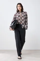 Pantalón negro de corte recto con tajos en el ruedo.