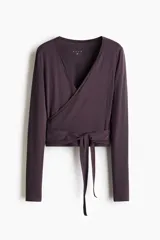 Top deportivo H&M Move de punto de modal suave, color marrón oscuro, con escote en V pronunciado, diseño cruzado y tiras para anudar en la cintura. De manga larga y corte ajustado.