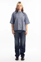 Pantalón de jean azul oscuro de corte recto, con refuerzos en las rodillas y bolsillos laterales. Diseño de estilo cargo con frente reforzado.