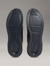 Championes Calvin Klein de malla color negro, con suela EVA y detalle de talón en tono tostado con logo cK.