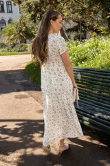 Vestido midi celeste con estampado de flores amarillas, escote en V, mangas cortas y falda escalonada con volados.